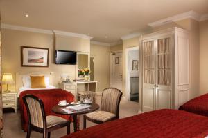 基拉尼基拉尼旅舍的酒店客房带一张床、一张桌子和椅子