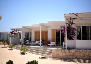 萨尔雷Villa Cristina Alojamento, Praia de Chaves, Boa Vista, Cape Verde, WI-FI的海滩上带门廊的房子