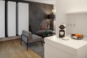 柏林AMANO HOME Apartments的厨房以及带桌椅的起居室。