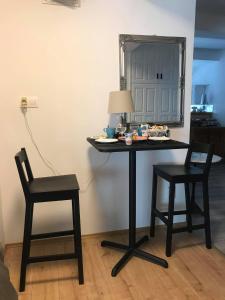 瑙吉考尼饶格里利亚酒店的一张桌子、两把椅子和一面墙上的镜子