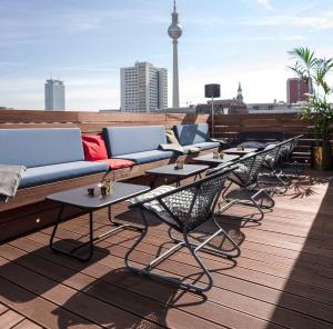 柏林Hotel ZOE by AMANO的屋顶上的一排桌子和沙发