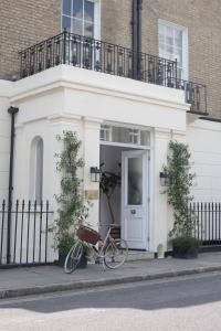 伦敦Inhabit Southwick Street, a Member of Design Hotels的停在白色房子前面的自行车