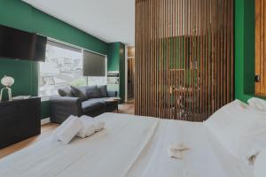 阿尔塔K-Houses B2的卧室配有白色的床和绿色的墙壁