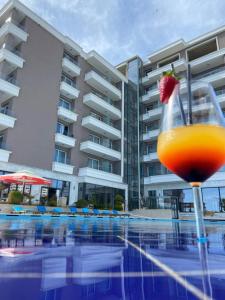 伏罗拉Kraal Hotel Vlore的坐在游泳池旁的桌子上喝一杯