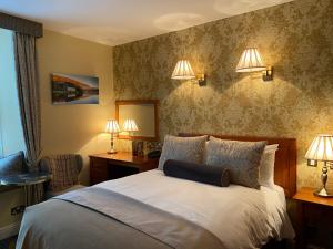 布拉尼布拉尼城堡酒店的卧室配有一张带两盏灯的墙壁床。