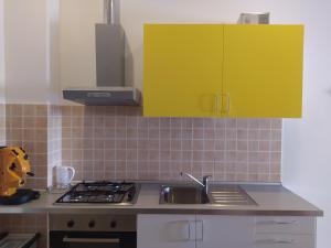 蒙泰斯佩尔托利La Medialuna的厨房配有黄色橱柜和水槽