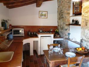 卡斯特利纳-因基安蒂Podere Patrignone的厨房配有桌子和炉灶。 顶部烤箱