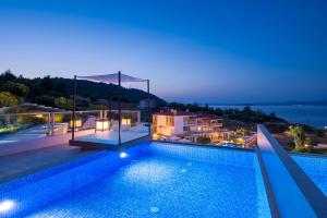 帕利乌里翁Villa D'Oro - Luxury Villas & Suites的夜间带游泳池的别墅