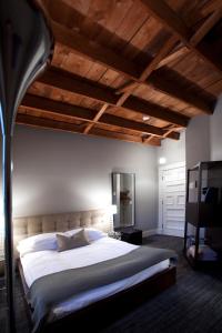 萨顿乐普勒贞特酒店和咖啡厅的一间卧室设有一张大床和木制天花板。