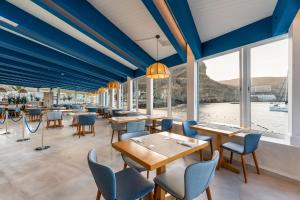莫甘海滩Hotel LIVVO Puerto de Mogán的餐厅拥有蓝色的天花板和桌椅