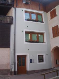 斯波尔马焦雷Casa Osti的白色的建筑,设有两扇窗户和一扇门