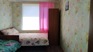 SzackЦипель 2的一间卧室配有床和一个带粉红色窗帘的窗户。