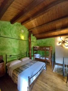 圣索菲亚CASINA LA QUERCIA的配有绿色墙壁和木制天花板的客房内的两张床
