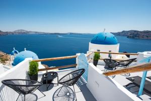 伊亚Luxus VIP Suites的阳台配有椅子,享有海景。