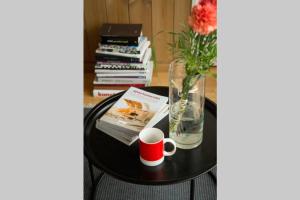 SakuCosy house by lake的一张带花瓶的桌子,一本书和一杯咖啡