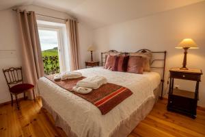 诺德什蒂Tradicampo Eco Country Houses的一间卧室配有带毛巾的床和窗户。
