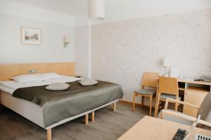 塔尔图塔尔图酒店的卧室配有一张床和一张桌子及椅子