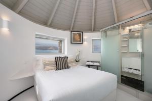 易莫洛林风车别墅的卧室配有白色的床和玻璃淋浴间
