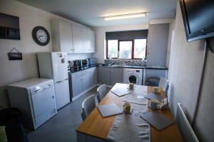 利物浦St Hilda Guesthouse的一间带桌子的厨房和一间带冰箱的厨房