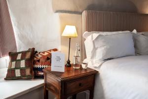 希普顿－安德威奇伍德The Lamb Inn的酒店客房配有一张床和一张带台灯的桌子