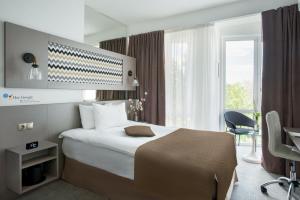 基希讷乌托马斯阿尔伯特酒店的配有一张床、一张书桌和一扇窗户的酒店客房