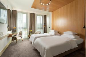 布拉格Hotel Golf Prague的酒店客房设有三张床和一张书桌