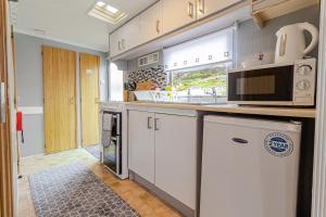 乌伊格Skye Holiday Chalets C1的厨房配有白色橱柜和微波炉