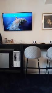 斯帕Room Of Lux SPA " TABARKA "的一张桌子、两把椅子和墙上的电视