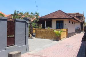库塔Jukung Villas Kuta的一座带木门和砖砌人行道的房子