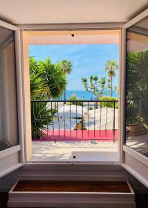 滨海卡涅Maison de la Marine的享有棕榈树海滩美景的窗户