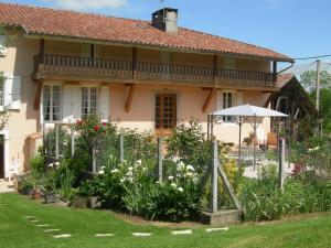 Caumont克洛斯弗勒里度假屋的一座花园,位于一座带遮阳伞的房子前