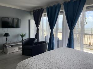 拉波勒Le Cheval Bleu的卧室配有床、椅子和窗户。