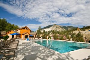 布埃纳维斯塔Mount Princeton Hot Springs Resort的一个带椅子的游泳池,背景是山脉