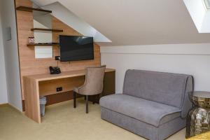 塞尼Hotel Meduza的客房设有书桌、椅子和电视。
