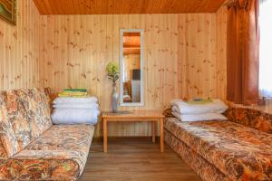 斯文托伊祖古提斯家园山林小屋的客厅配有两张沙发和一张桌子
