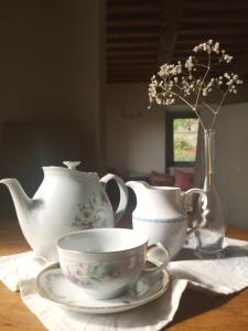 阿雷佐Alba Morus Bed e Breakfast sentiti a casa nel cuore della Toscana的茶几,茶壶,茶杯和花瓶