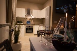 莫诺波利Appartamento Antonacci的厨房配有一张桌子,上面放有两杯葡萄酒