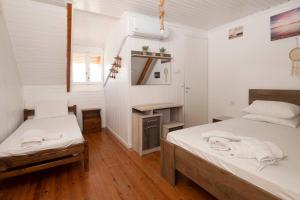 吉亚洛瓦Giorgos House Attic的配有白色墙壁和木地板的客房内的两张床