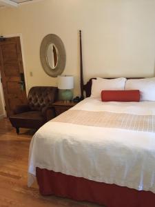 圣巴巴拉老鹰旅馆的一间卧室配有一张床、一把椅子和镜子