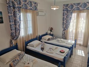 埃尔莫波利斯Aiantas的配有两张床铺的蓝色和白色窗帘