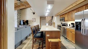 斯诺马斯村Timberline Condominiums 1 Bedroom plus Loft Deluxe Unit A3C的厨房配有带椅子的柜台和冰箱。