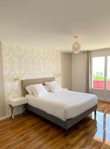 滨海卡涅Maison de la Marine的一间卧室设有一张大床和一个窗户。