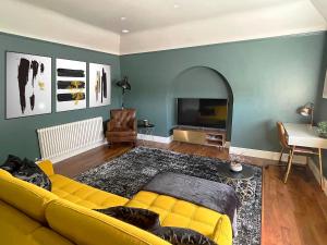 约维尔'The Loft'的客厅配有黄色沙发和电视