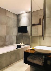 卡尔塔尼塞塔Duomo House的浴室配有盥洗盆、浴缸和盥洗盆