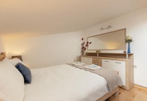 卢什蒂卡Apartment Sea Breeze的卧室配有白色的床和大镜子