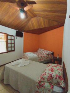西波山Espaço Vilarejo Pousada的一间卧室配有两张床和吊扇