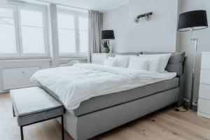 明斯特2-Zimmer City Apartment 57m² mit King Size Bett und Küche的白色卧室配有一张大床和椅子