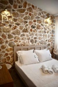 奥马斯帕纳吉亚斯Ktima Panagias的一间卧室设有石墙和床