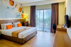 丹戎潘丹Golden Tulip Essential Belitung的酒店客房设有一张床和一个阳台。