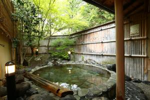 松本泉屋森贝酒店的花园中的一小池水